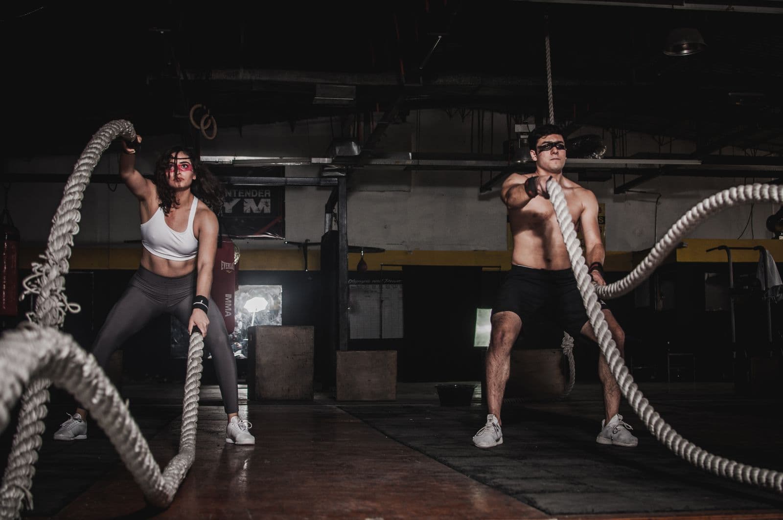 Two athletes building strength with battle ropes